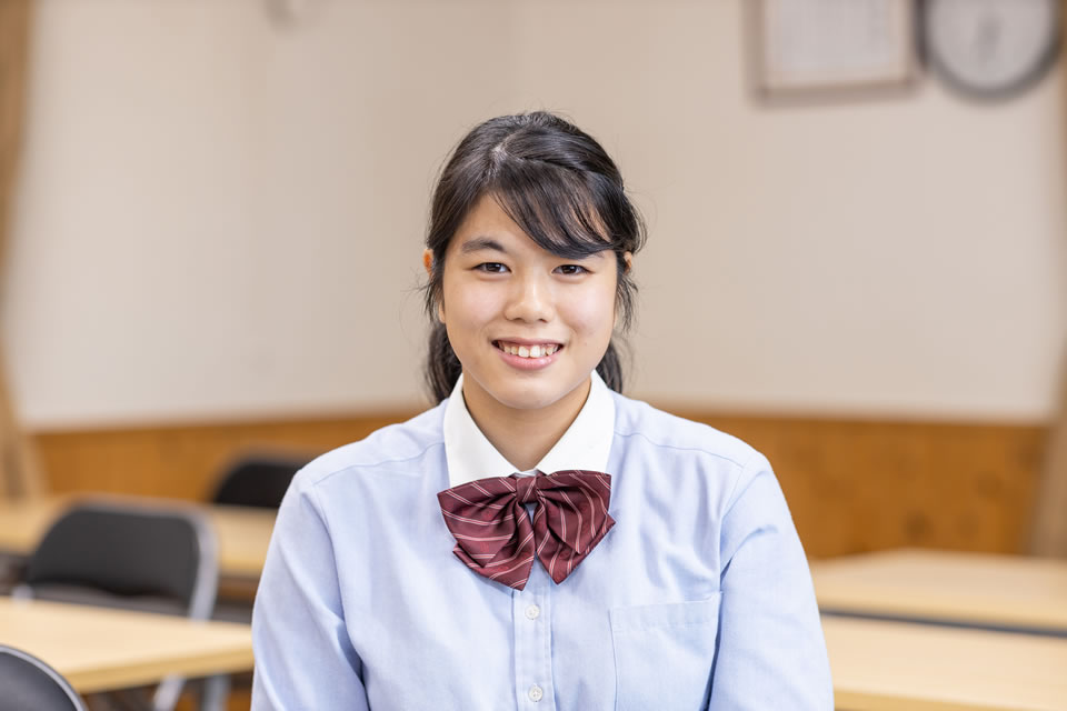 笑顔が素敵な赤いリボンを付けた女子中学生