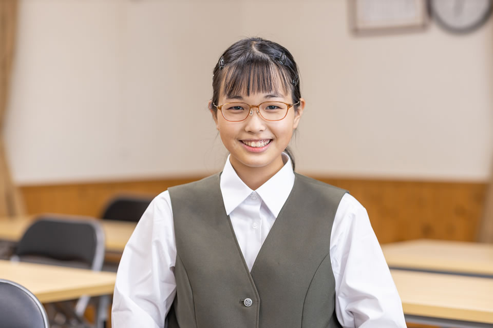 眼鏡をかけた優しい笑顔の女子中学生